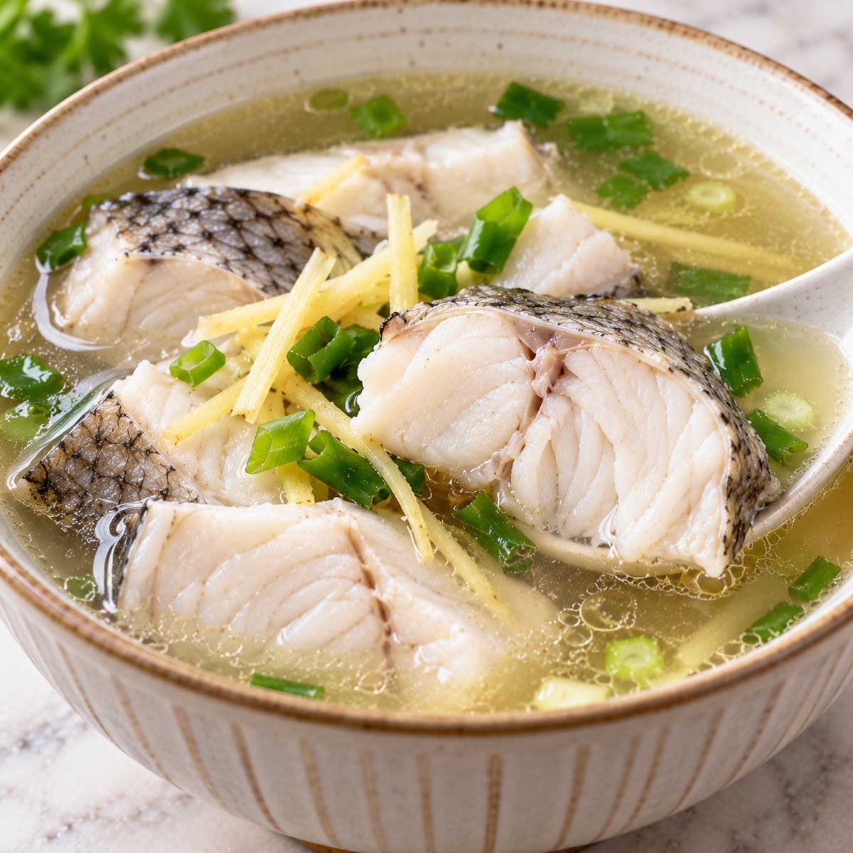 夾起魚湯中的魚塊查看白色魚肉熟度