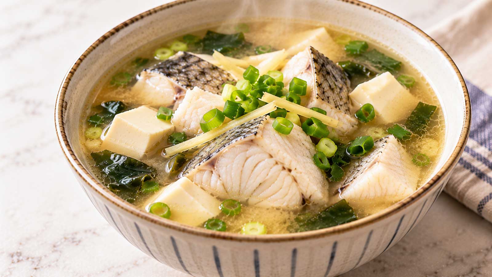 盛有魚塊、豆腐、薑絲與蔥花的家常味噌魚湯