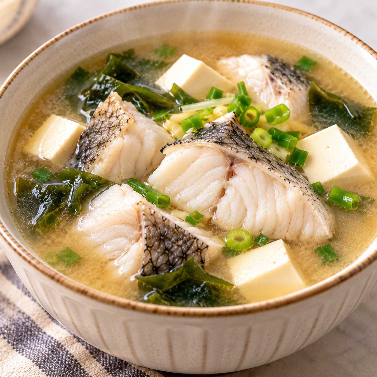 夾起味噌魚湯中的魚塊查看白色魚肉熟度