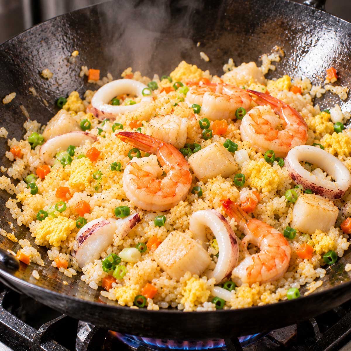 海鮮炒飯步驟:將蝦仁與魷魚炒熟,再與白飯拌炒