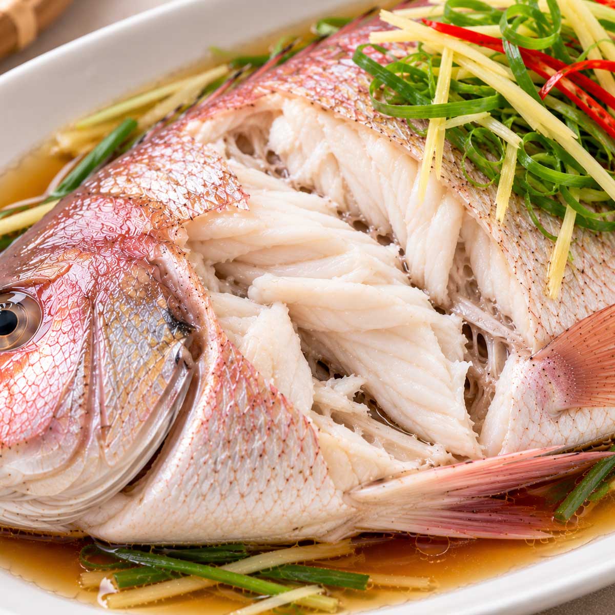 撥開清蒸鯛魚最厚處查看白色魚肉熟度
