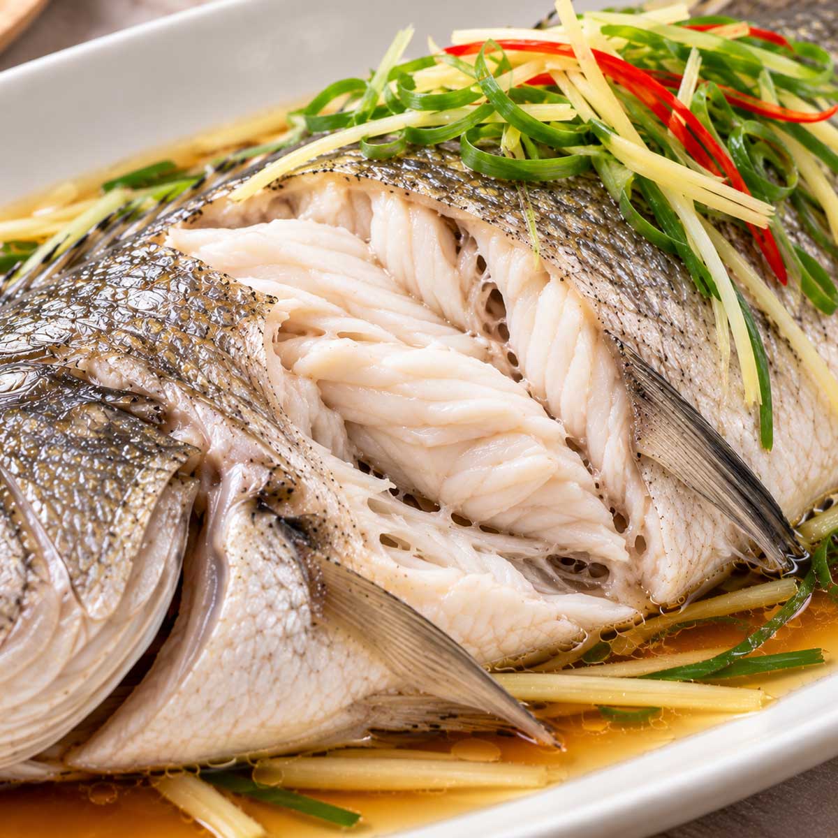 撥開清蒸鱸魚最厚處查看白色魚肉熟度